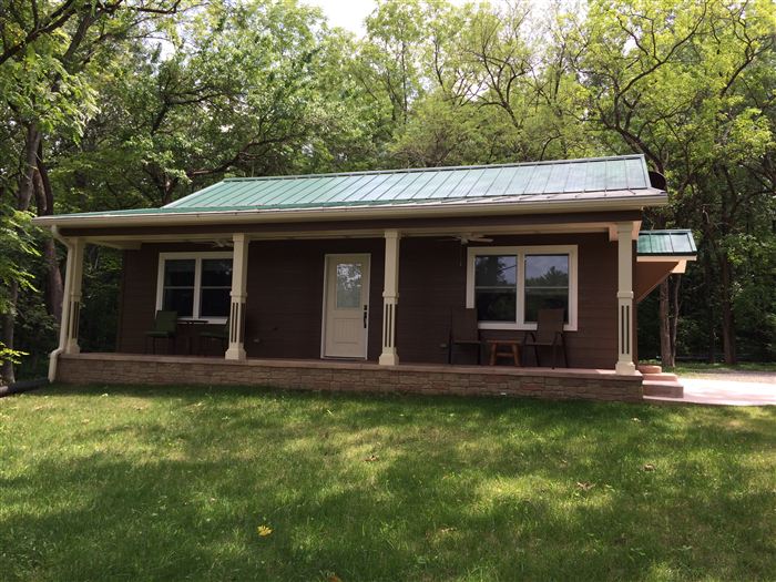 Renovated cottage exterior with covered porch and metal roof, Jersey County Illinois