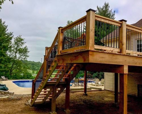 Elevated wood deck renovation with staircase overlooking a pool in the Riverbend area