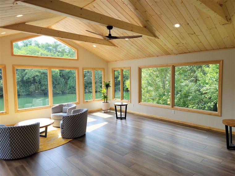 Vaulted wood-ceiling sunroom addition with panoramic river views, built by Brunaugh Construction & Design